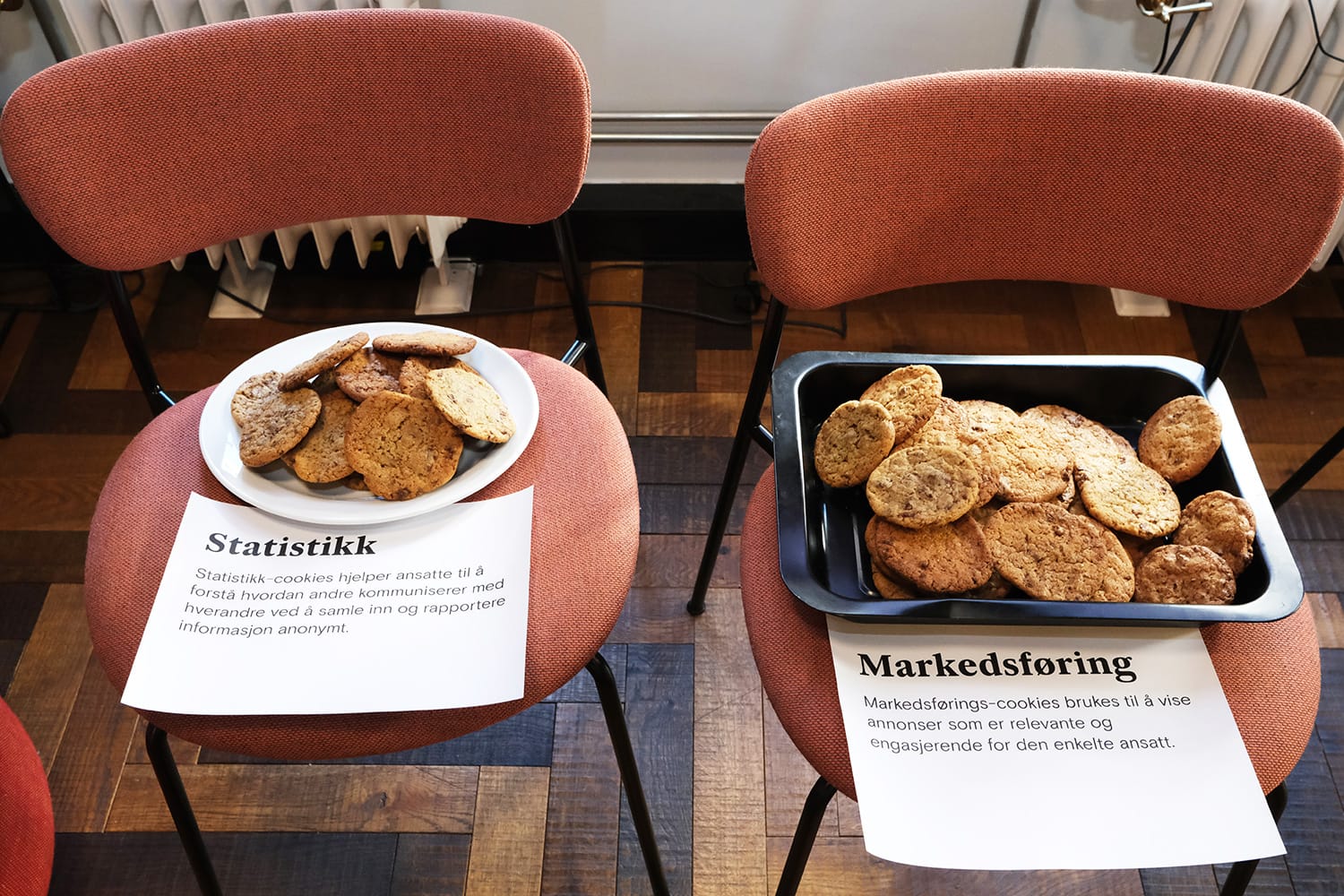 Fotografi av to fat med cookies, med ark som forklarer forskjellige typer cookies på på internett, som statistikk-cookies og markedsførings-cookies.