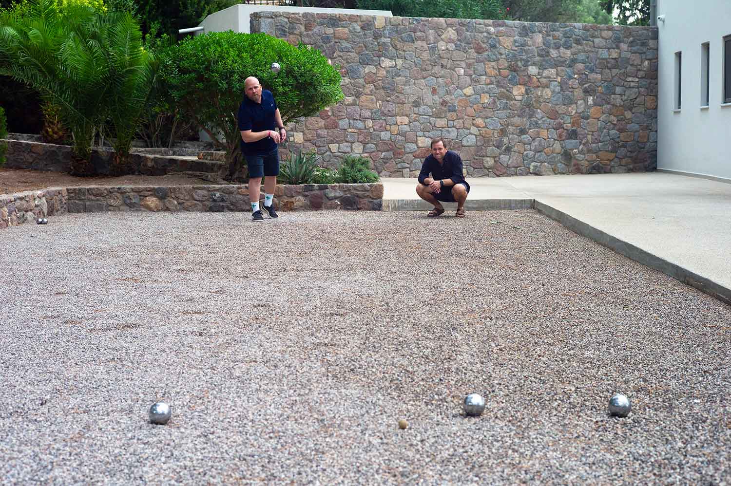 Fotografi av to Fiken-ansatte som spiller petanque.